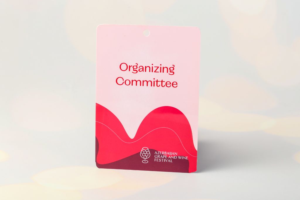 Badge Azerbaijan Grape and Wine Festival — Organizing Committee, pink-red design, rectangular, hole at top