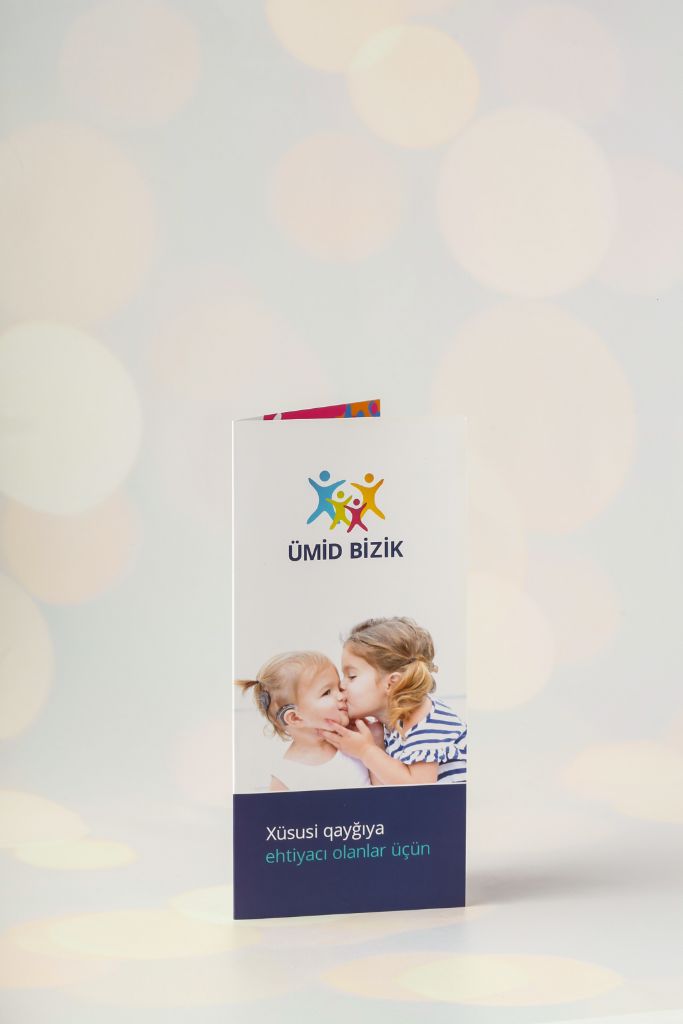 Ümid Bizik booklet — DL cover, white background, colour logo, children's photos, blue bar at bottom