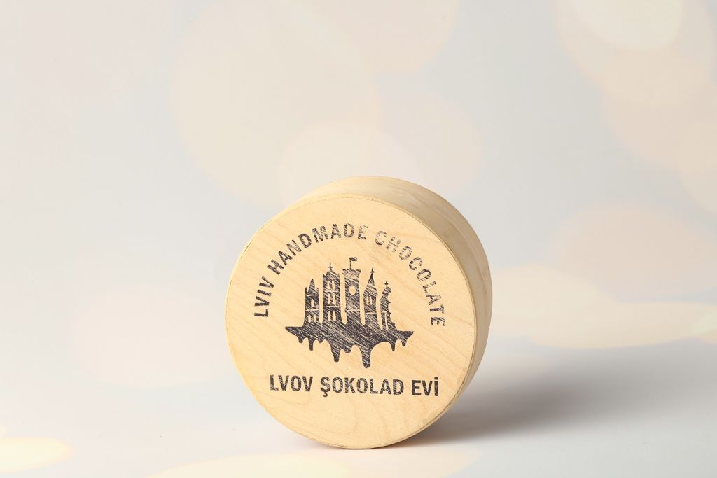 Round wooden box Lviv Handmade Chocolate — top view, laser-engraved logo