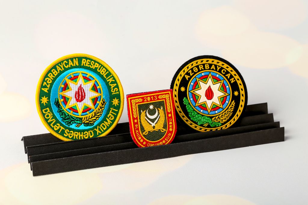 Three embroidered patches — Dövlət Sərhəd Xidməti (round, blue/gold, coat of arms), military chevron 2013 (shield, olive/red) and Azərbaycan (round, black-gold, state coat of arms)