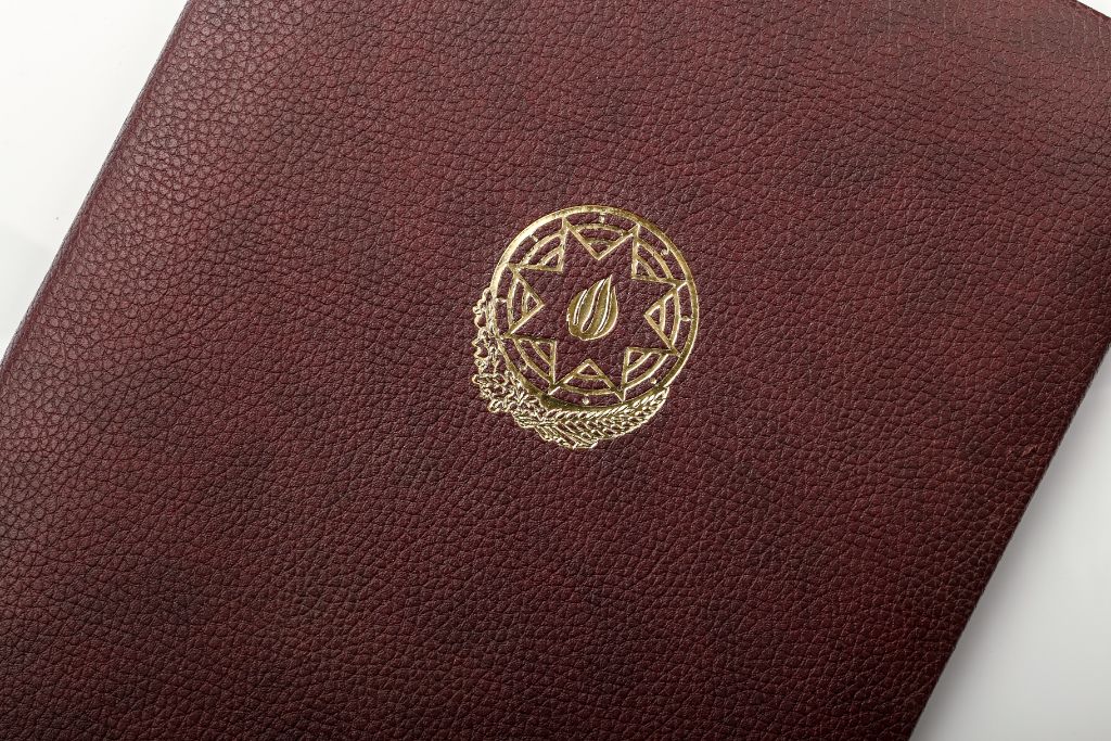 Pebble leather — gold coat of arms close-up