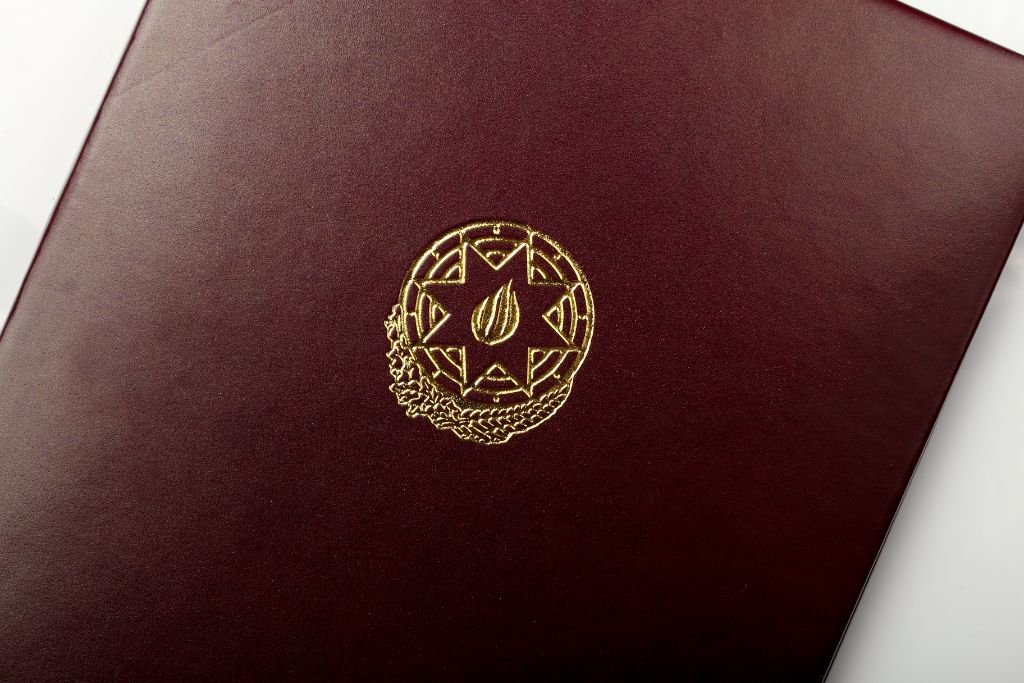 Smooth leather folder — burgundy, gold coat of arms close-up