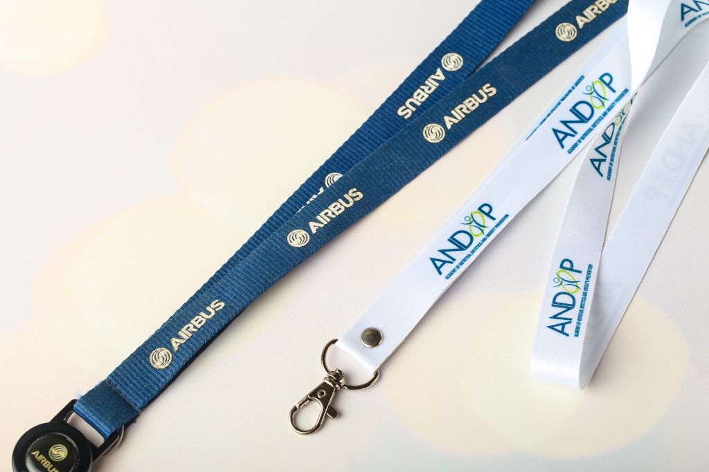 Airbus (blue, sublimation, snap-hook) and ANDOP Academy (white, silkscreen, snap-hook) lanyards — branded badge lanyards