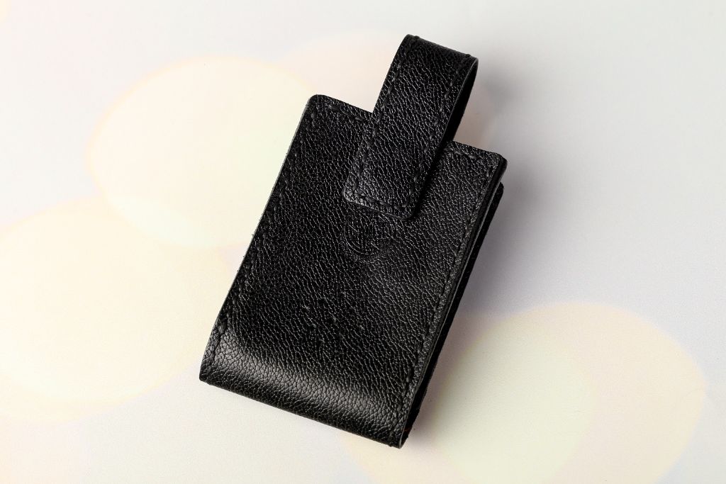 Leather card holder closed — black pebble leather, magnetic clasp