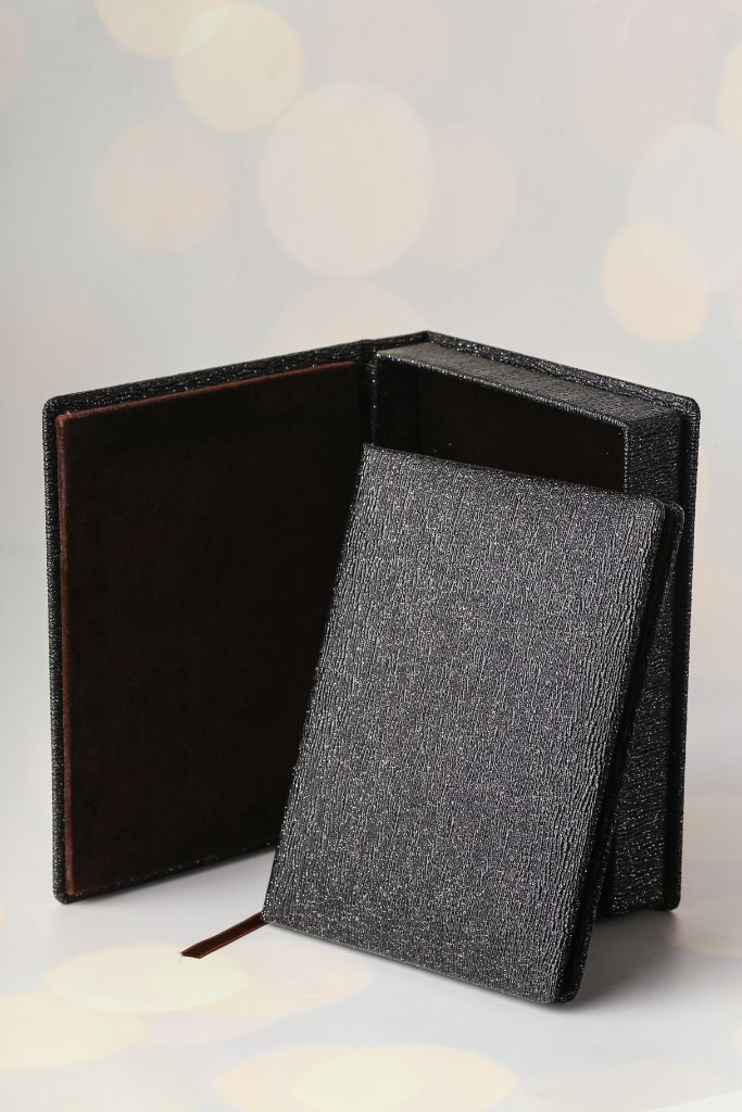 Open leather notebook — black textured cover, suede interior, ribbon bookmark