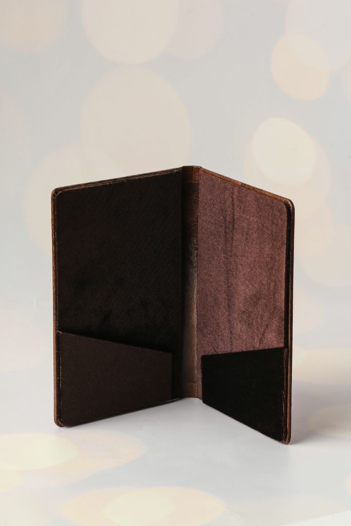 Sumakh menu — open leather folder, inner sleeve pockets for inserts