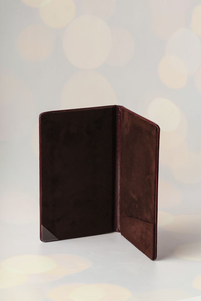 Sumakh menu open — leather ring-binder spread, suede lining, interior view