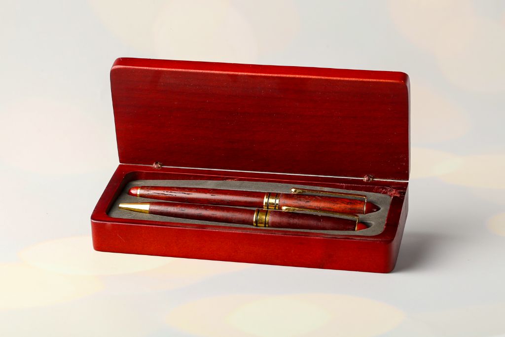 Wooden pen box open — dark red wood, grey velvet insert, pen inside