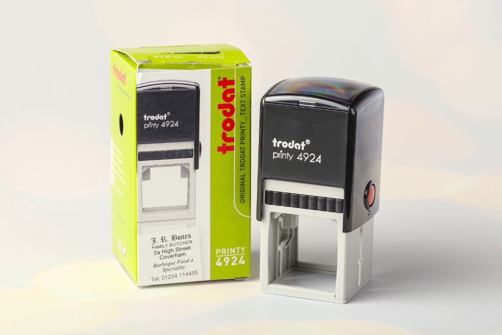 Trodat Printy 4924 — square 40×40 mm, black, front view of box with J.R.Bones impression example