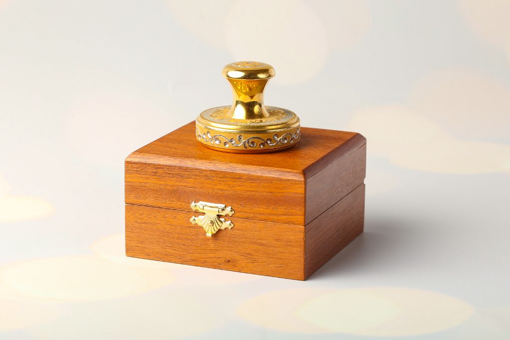 Gold VIP stamp placed on closed wooden casket — presentation view