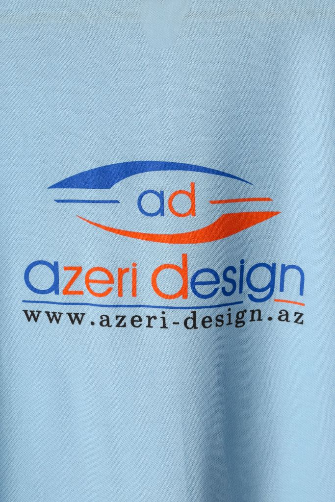 Azeri Design logo print on sky blue polo back — close-up, screen print