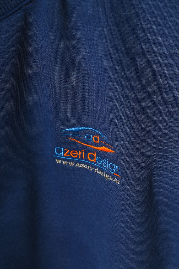 Logo embroidery on chest of navy sweatshirt — close-up