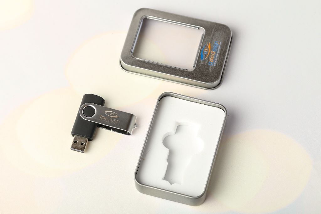 Owl Design Swivel USB — open tin box with white EVA insert holder, drive beside it